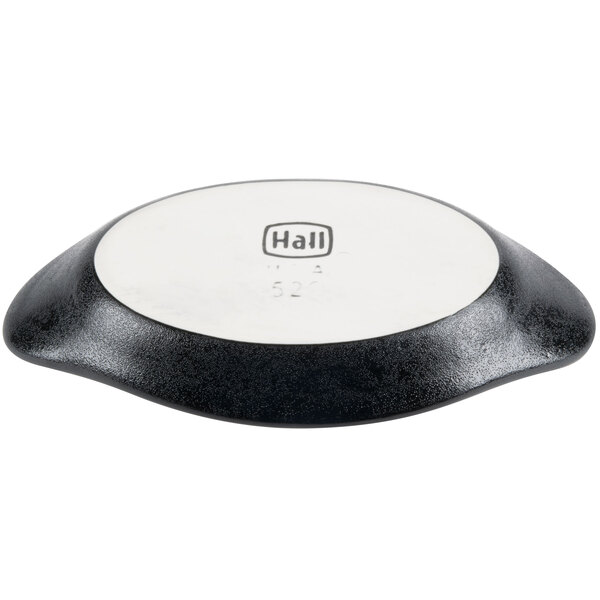 A white circular dish with a black Hall China logo on it.