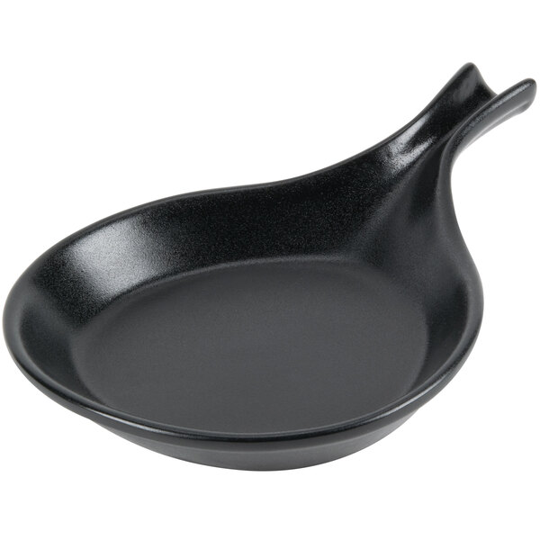 A black china fry pan server with a handle.