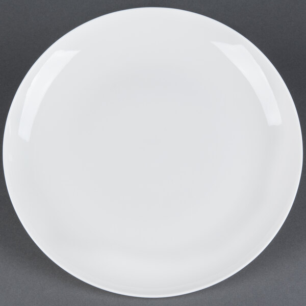 A CAC white bone china coupe plate with a white rim on a gray surface.