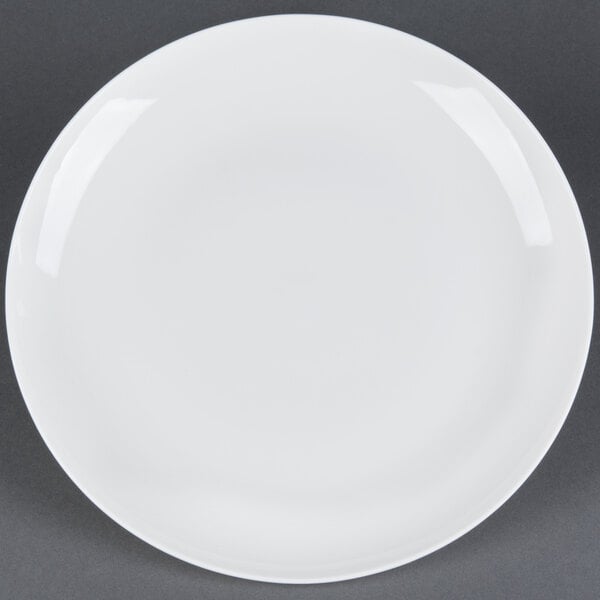 A CAC Majesty European bone china coupe plate with a white rim on a gray surface.