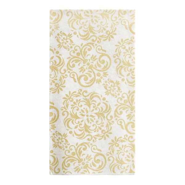 A white guest towel with a gold decorative pattern.