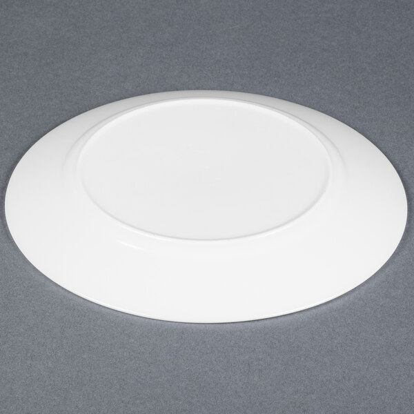 An Arcoroc white glass plate on a grey table.