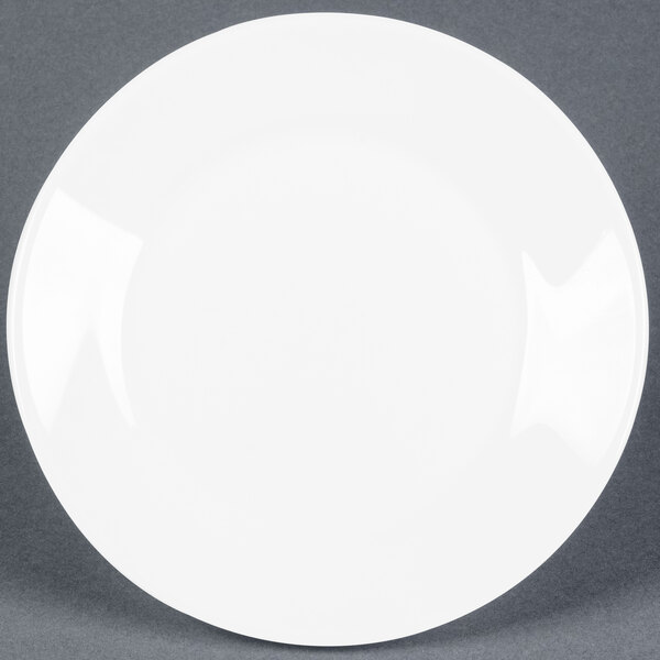 An Arcoroc white glass plate with a small rim on a gray surface.