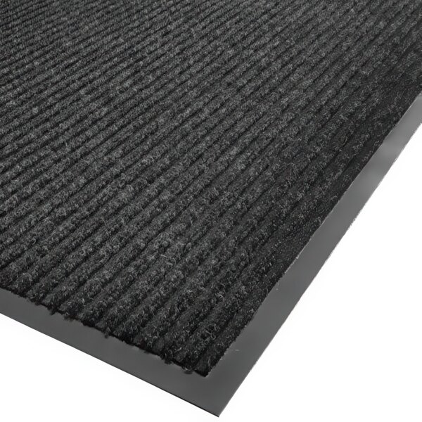 A close-up of a charcoal needle rib carpet mat with a gray border.