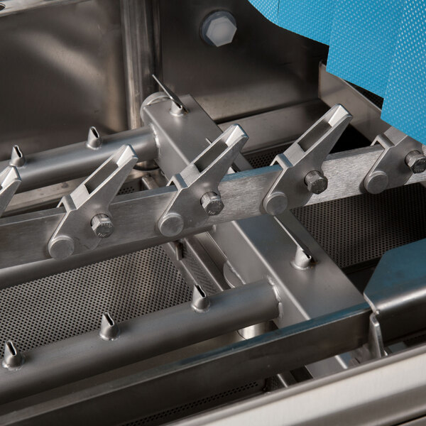 A close-up view of the stainless steel interior components of a commercial conveyor dishwasher.