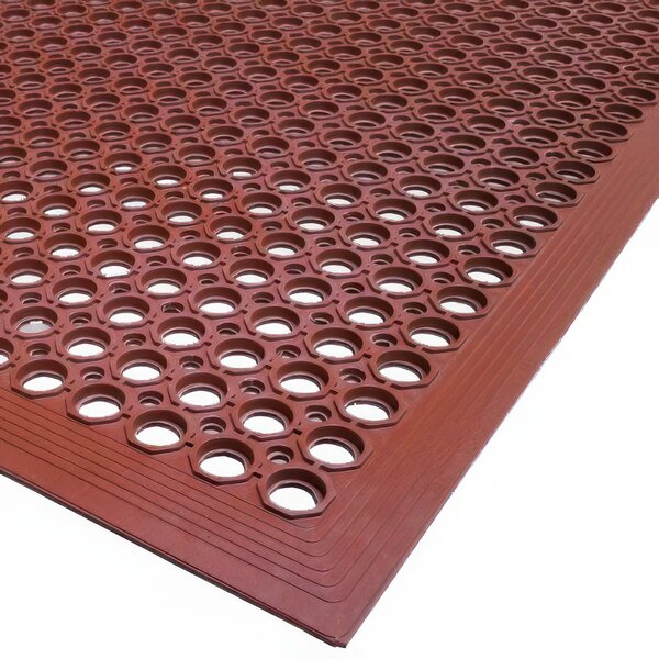 A close-up of a red rubber Cactus Mat with holes in it.