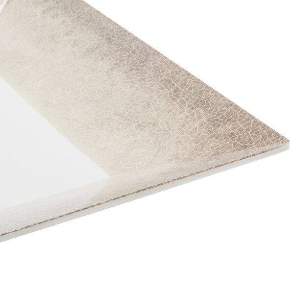 A close up of a Thunder Group Jazz square melamine plate with a white surface and a beige crackle-finished border.