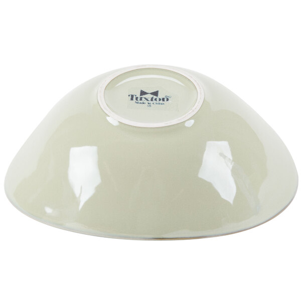 A white Tuxton China bowl with a logo on the rim.