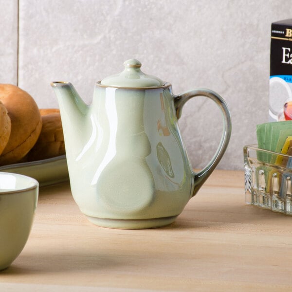 A Tuxton TuxTrendz Sagebrush teapot and cup on a table.