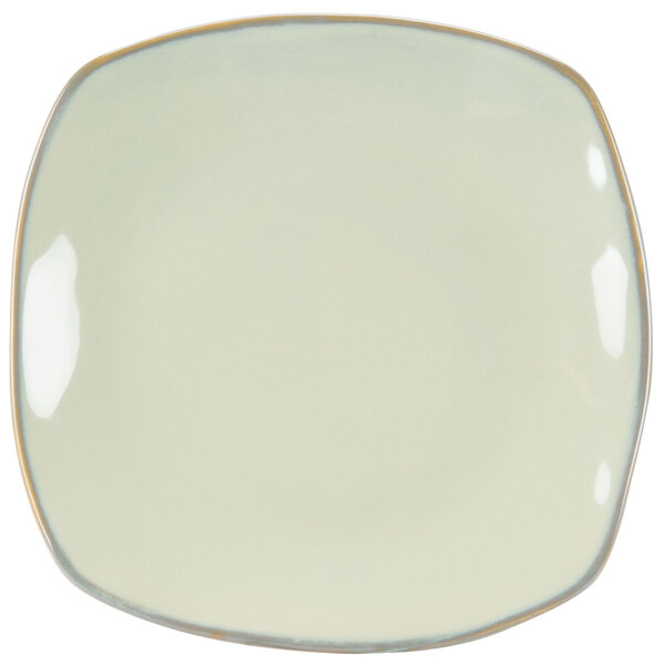 A white square Tuxton china pasta plate with gold trim.