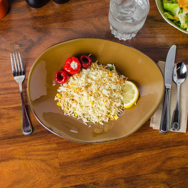 A TuxTrendz Artisan Mojave china plate with rice and vegetables, a fork, and a knife on a table.