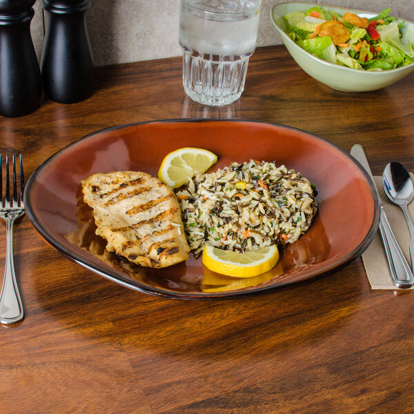 A TuxTrendz Artisan Red Rock china platter with food on a table.