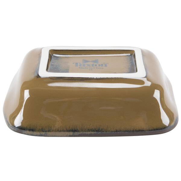 A close-up of a brown rectangular Tuxton side dish with a white border.