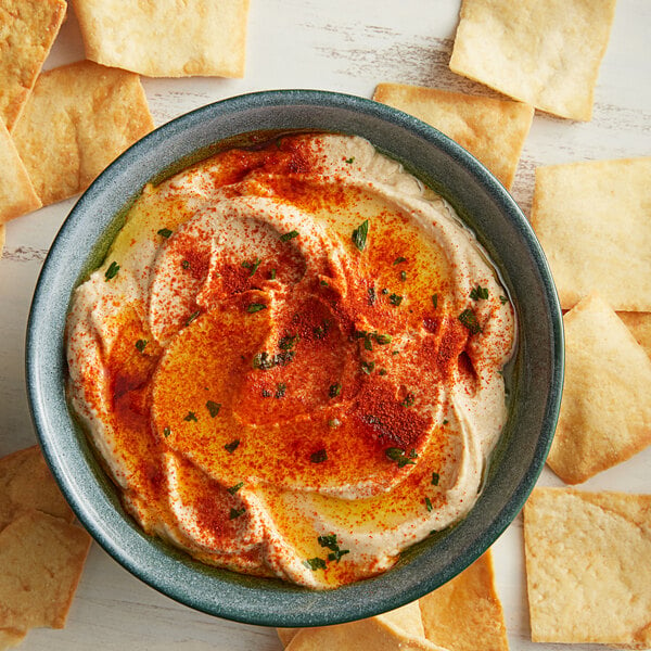 A close up of a bowl of hummus with smoked paprika.