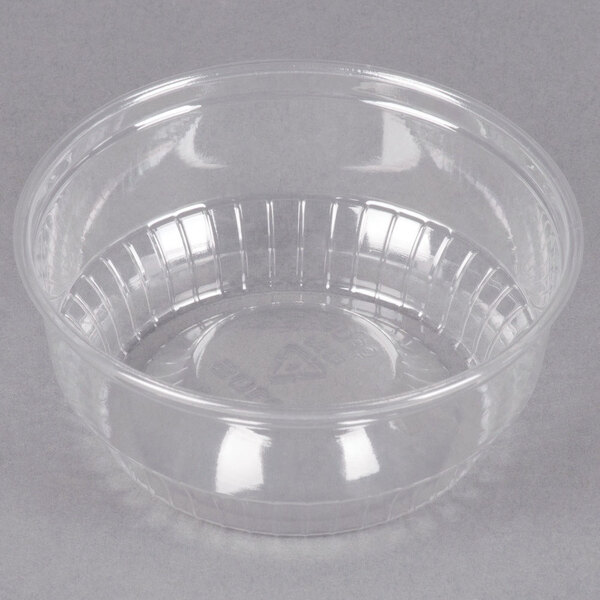 A clear plastic Solo sundae cup on a gray background.