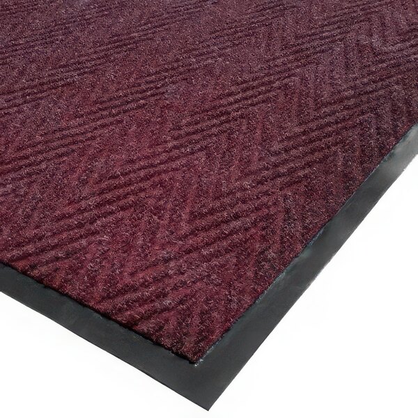 A burgundy Cactus Mat entrance mat with a chevron pattern and black trim.