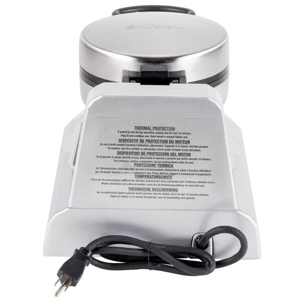 A silver and black Waring single waffle cone maker on a counter with a cord attached.