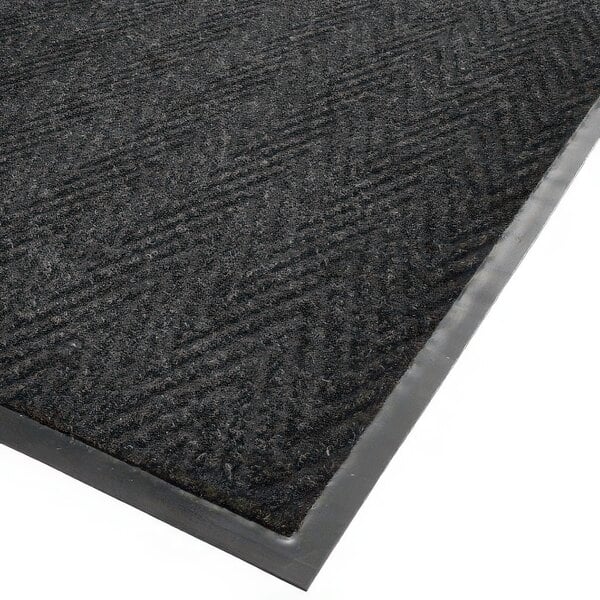 A black Cactus Mat Chevron Rib Herringbone scraper mat with a grey border.