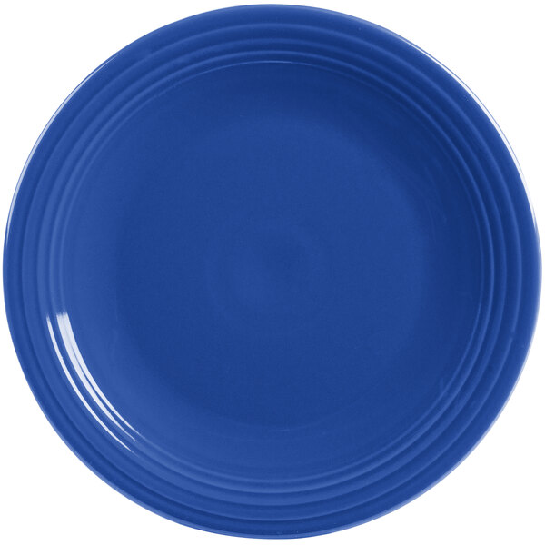 A close-up of a blue Fiesta® Dinnerware chop plate with a rim.