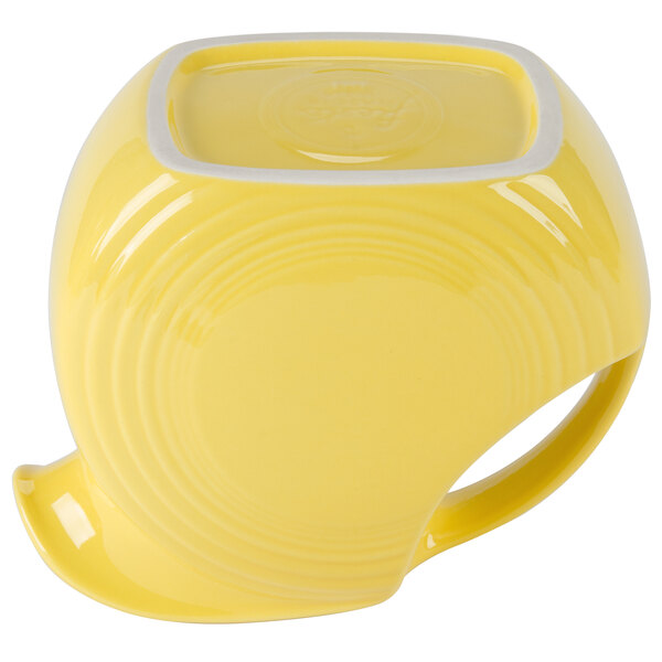 A close up of a yellow Fiesta disc pitcher with a handle containing a yellow liquid.