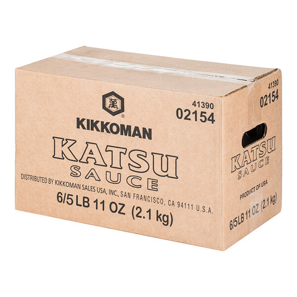 A cardboard box labeled 'Kikkoman Katsu Sauce' with printed product details and a handle cutout on the side.