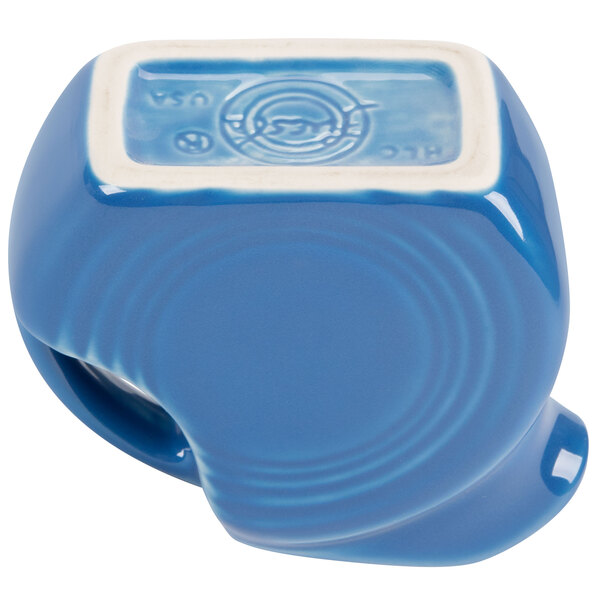 A blue ceramic Fiesta disc creamer pitcher with a white interior.
