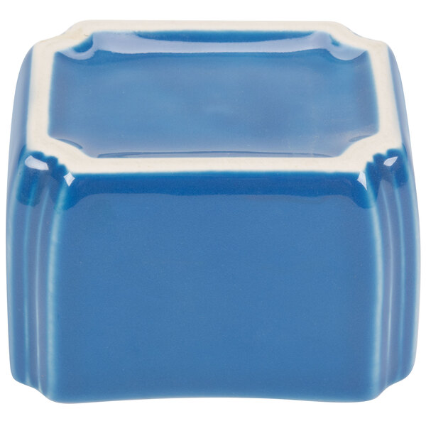 A blue and white ceramic cube with a square dish on top.