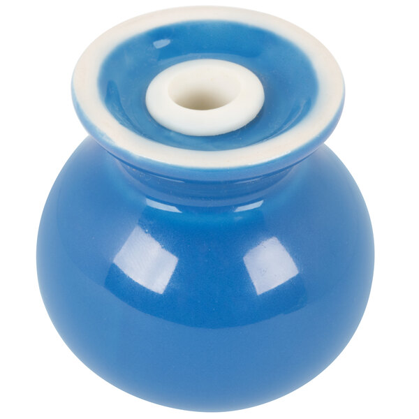 A blue ceramic salt shaker with white squares on the bottom.