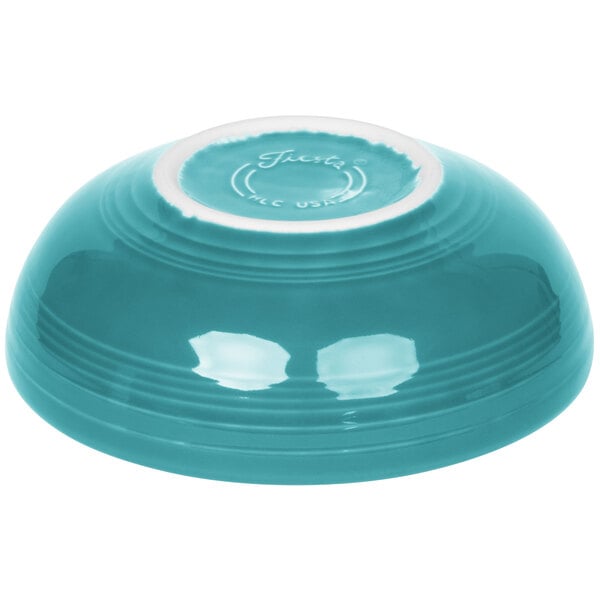 A turquoise bowl with a white rim.