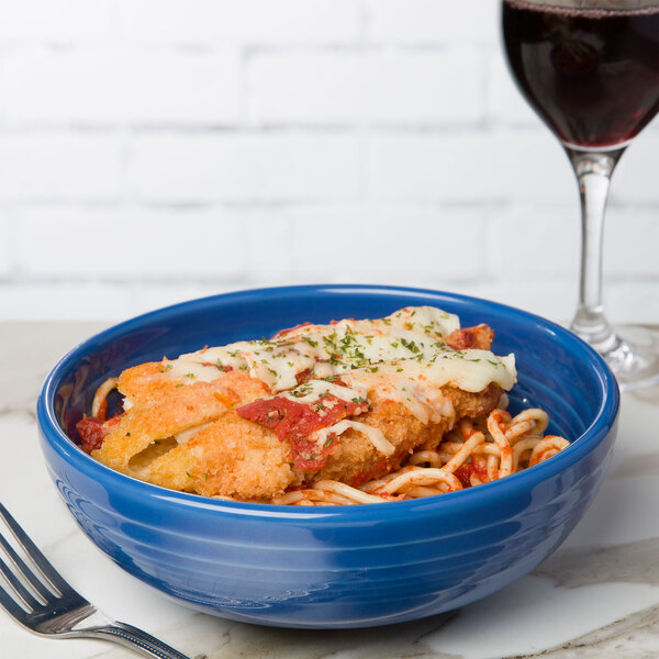 A Fiesta Bistro bowl filled with food next to a glass of wine.