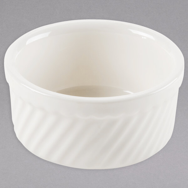 A white Tuxton china ramekin with a wavy design.