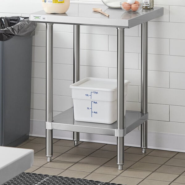 A Regency stainless steel work table with an undershelf holding a white plastic container.