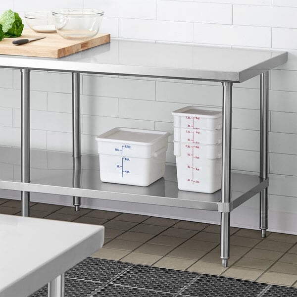 A Regency stainless steel undershelf for a work table with white containers on it.