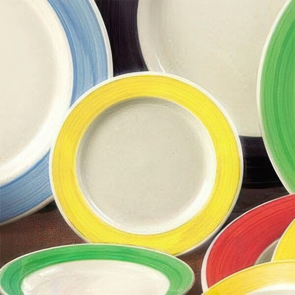 A close-up of a yellow and green CAC stoneware bowl with a yellow ring on the edge.