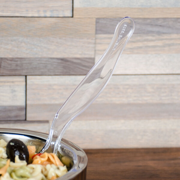 A Fineline clear plastic serving spoon in a bowl of food.