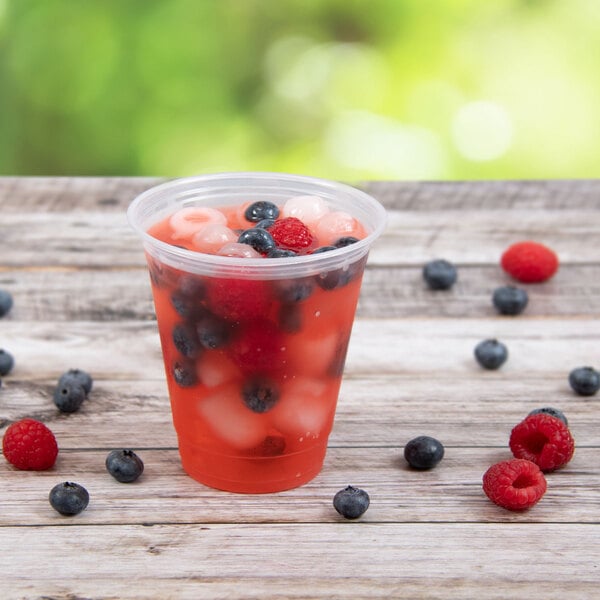 A Dart ClearPro plastic cup filled with fruit and ice.