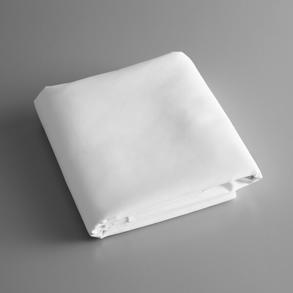 A folded white tablecloth on a gray surface.