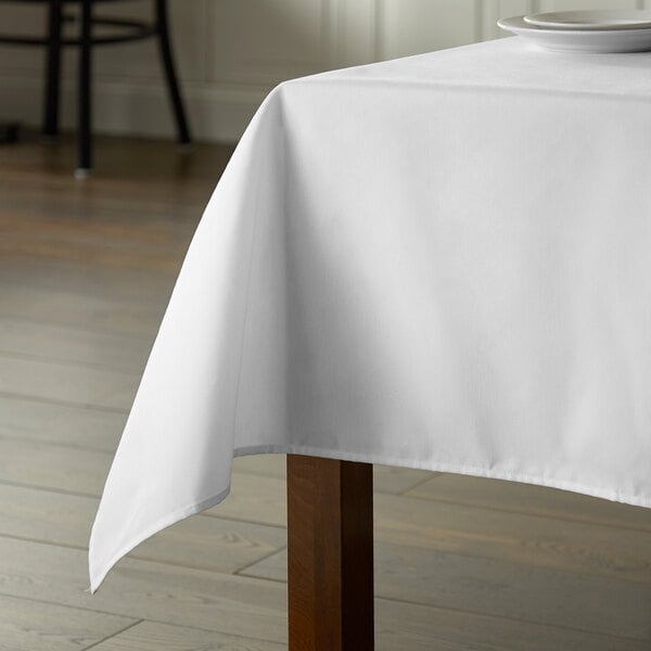 A rectangular white Intedge tablecloth on a table.