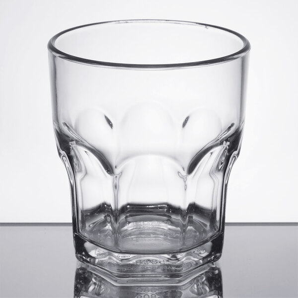 A clear Dinex SAN plastic tumbler with a curved rim.