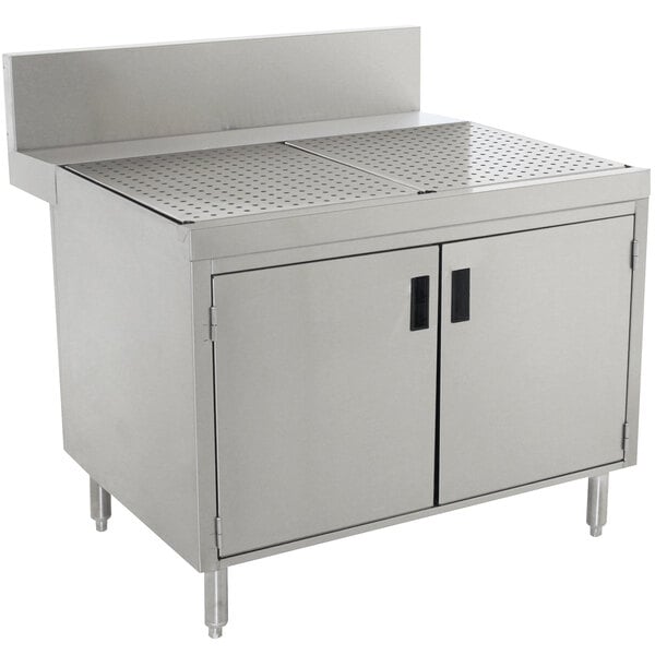 A stainless steel Advance Tabco commercial kitchen cabinet with doors for a drainboard.