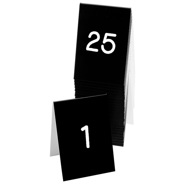 A stack of black Cal-Mil table tents with white numbers on them.