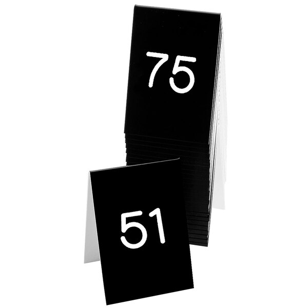 A stack of black Cal-Mil table tents with white numbers on them.
