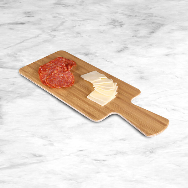 A white rectangular faux bamboo melamine serving board with a handle holding slices of cheese and salami.