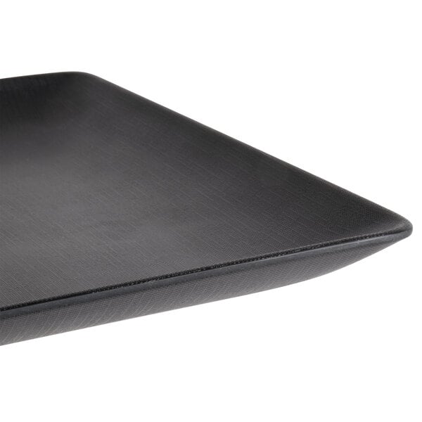 A close-up of an Elite Global Solutions black square plate with a metal edge.