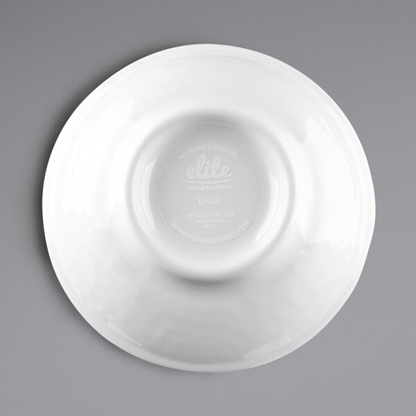 A white Elite Global Solutions melamine ramekin with a circular design on a white plate.