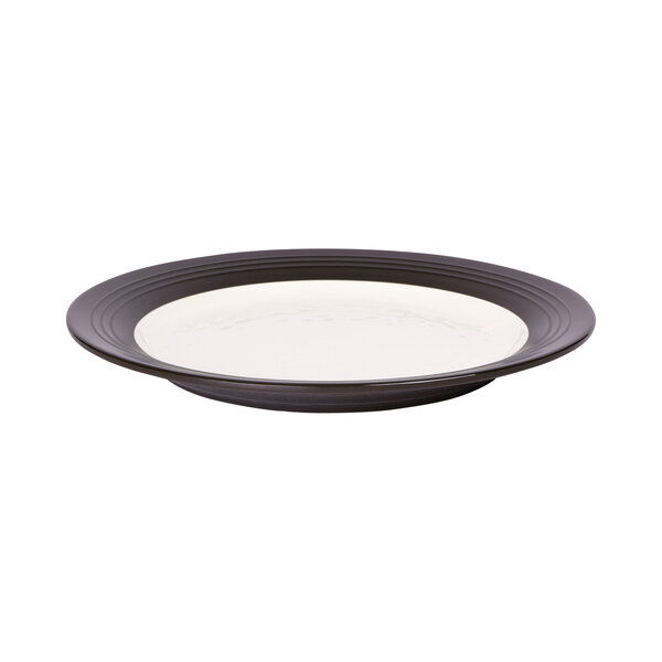 An Elite Global Solutions Durango two-tone melamine plate in antique white and chocolate with a rim.