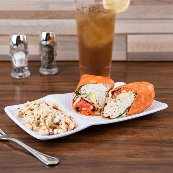 A white melamine platter with a sandwich and tortilla wrap on it.