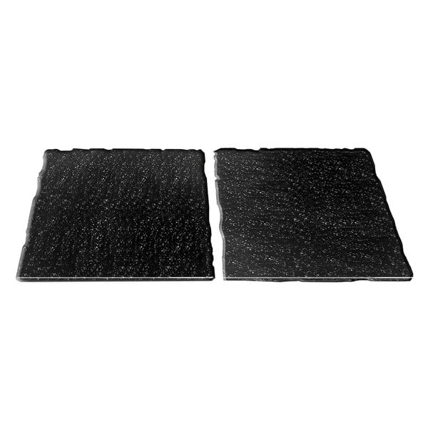 Two black rectangular tiles with white specks on a white background.