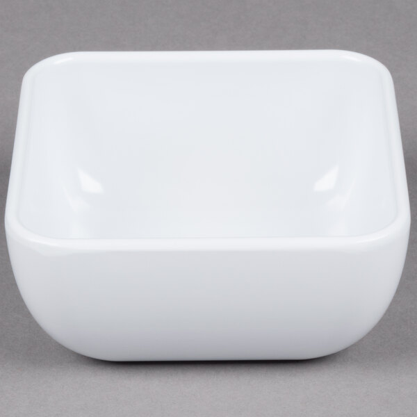 A white square bowl on a gray surface.