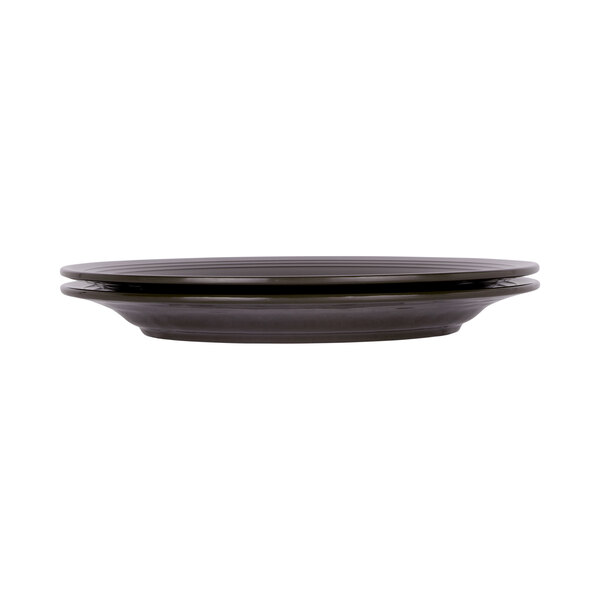 A black Elite Global Solutions round melamine plate with a round edge and a rim.